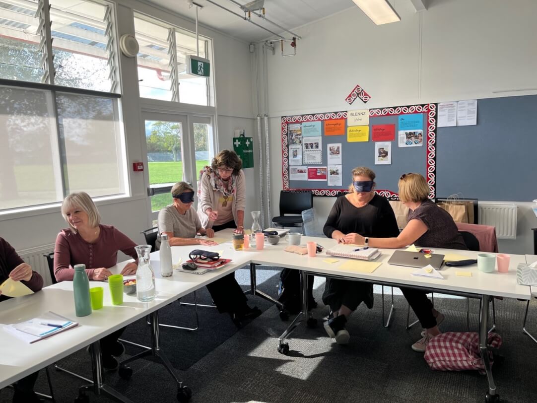 A group of six RTV and DOM sitting at a table working together in pairs