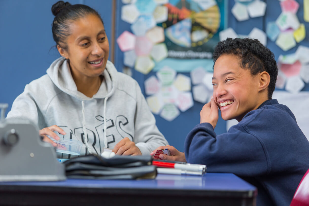 Boston and the teacher's aide sitting at a table.