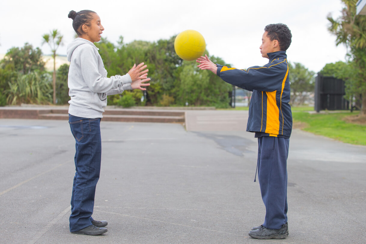 Boston throws a ball with the teacher's aide.