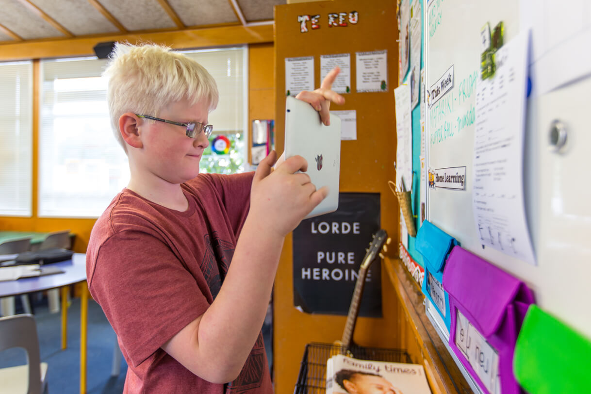 Corran standing in front of whiteboard with his iPad.
