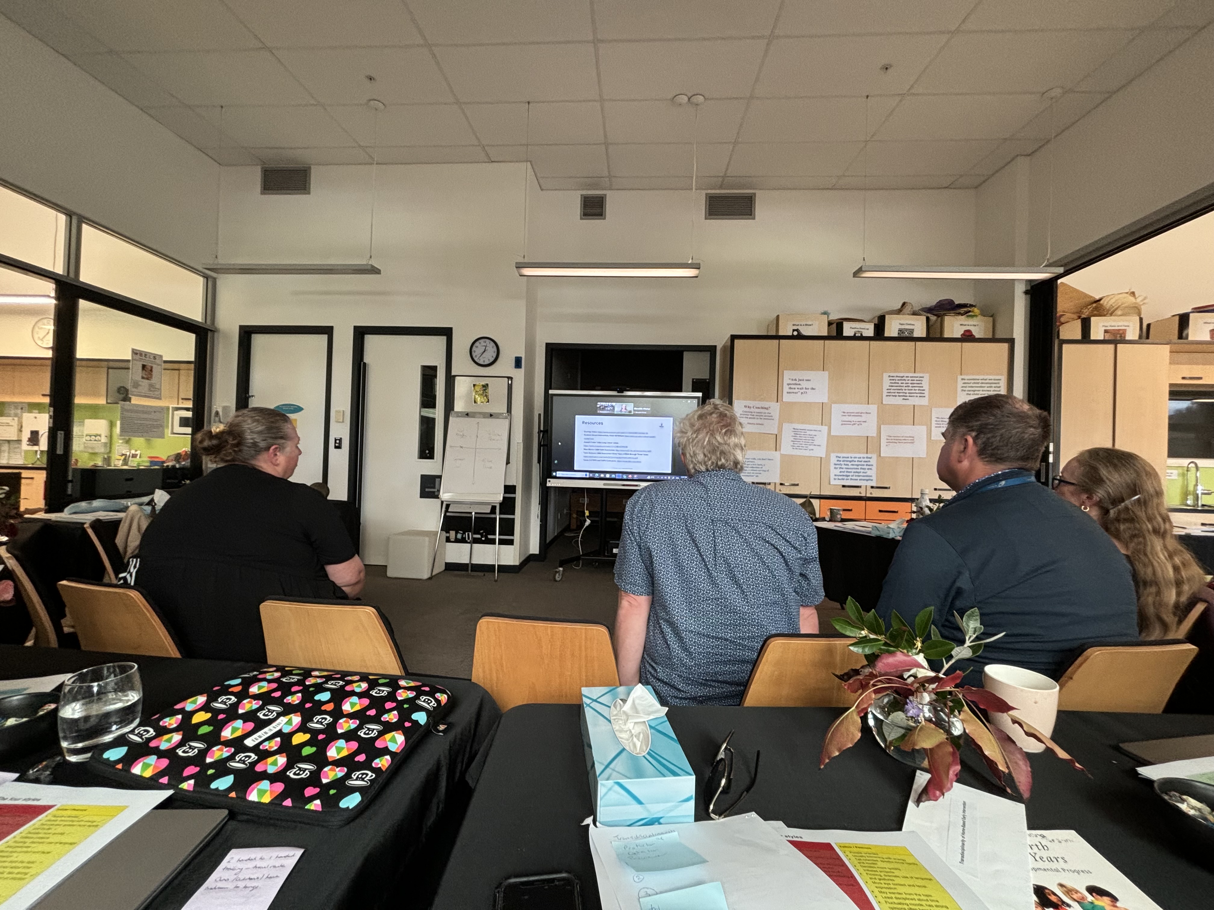 The DOM and BELS team members sitting on chairs in front of a screen while taking part in professional development days based at Homai in Auckland.