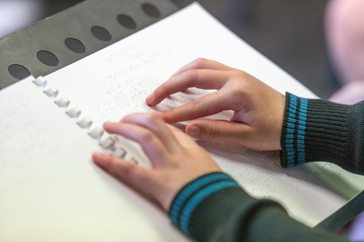 Fingers on a braille page.