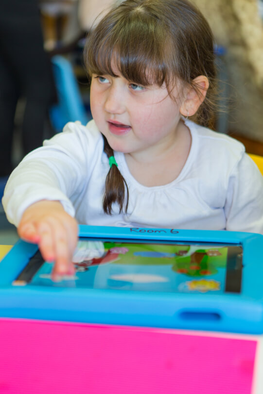 Giana sitting with her fingers on the iPad.