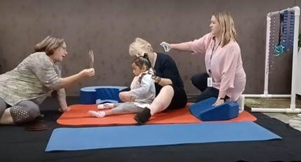 NAS therapists and RTV working together to provide the best opportunity for young girl to use vision and her hands