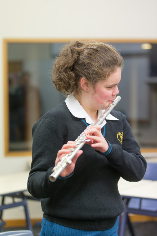 Renee standing playing her flute.