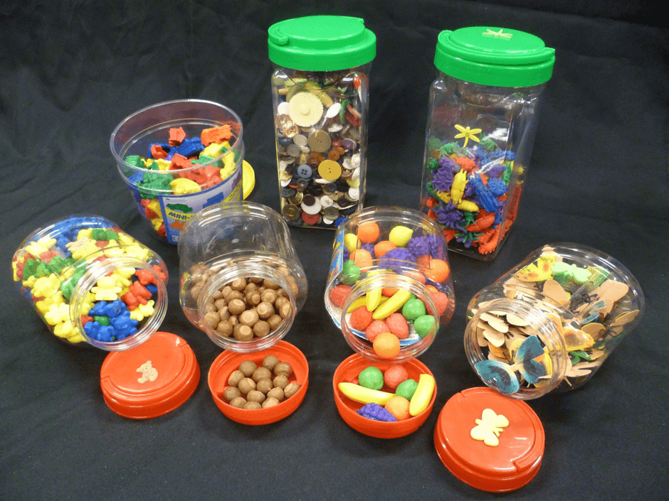 Seven jars of objects for sorting including acorns, buttons and a range of plastic representations of animals, vehicles, fruits and insects.