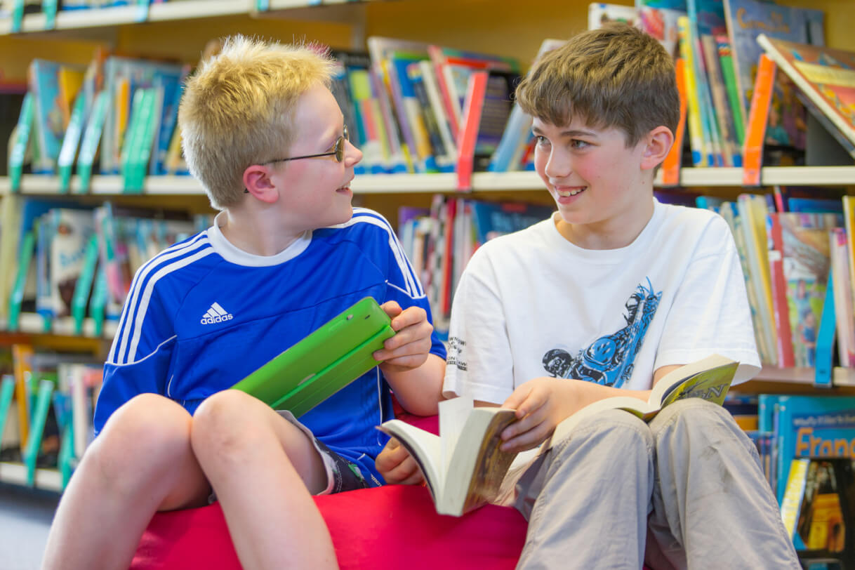 Mitchell and his classmate sitting on a beanbag in the library.