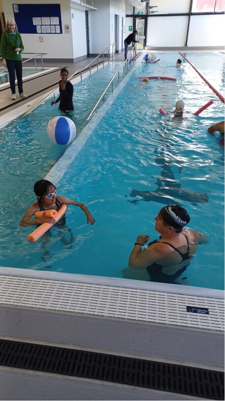 six students in the swimming pool and four RTVs watching students in the pool